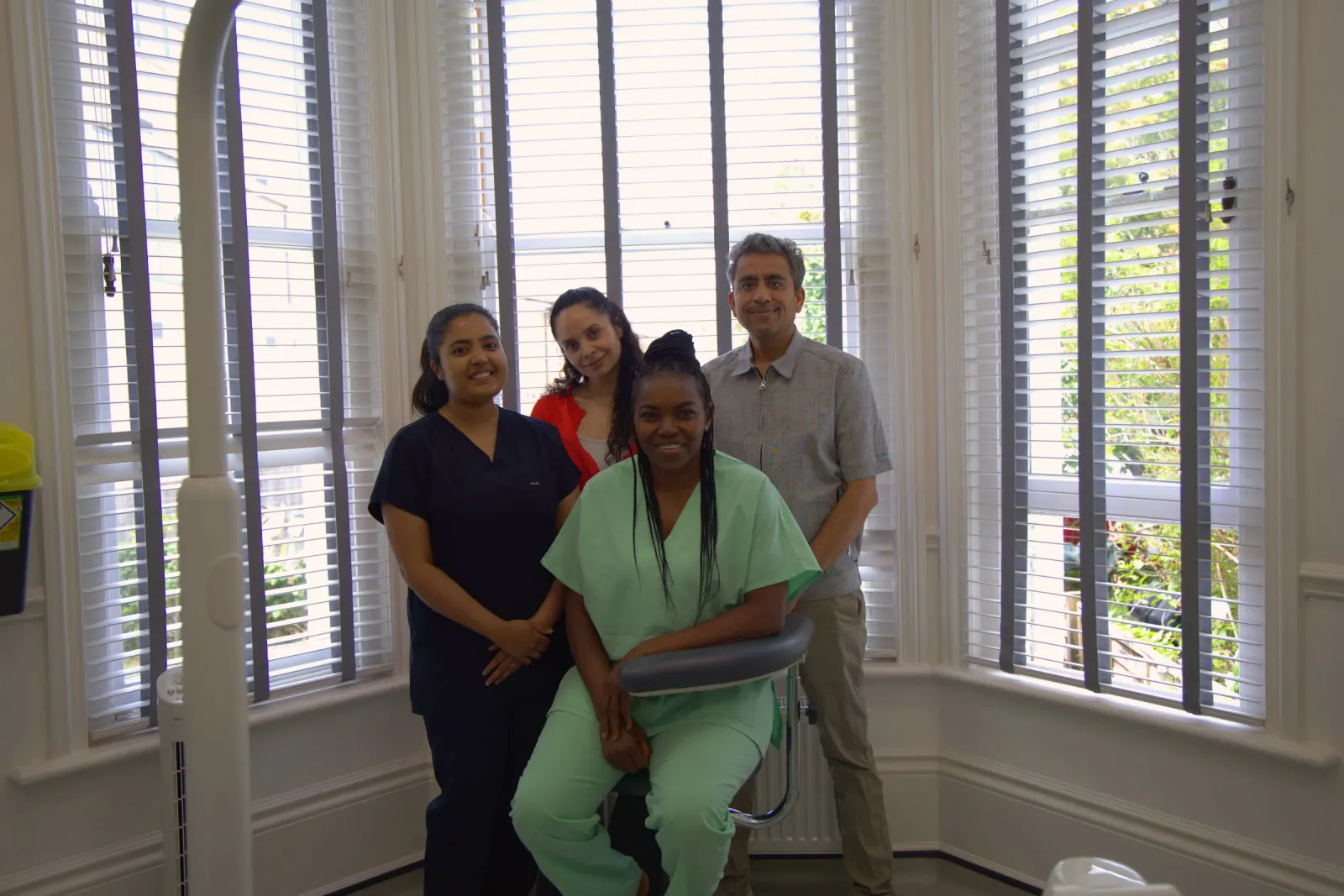 The Aspen Dental Care team together in the bay-window waiting room