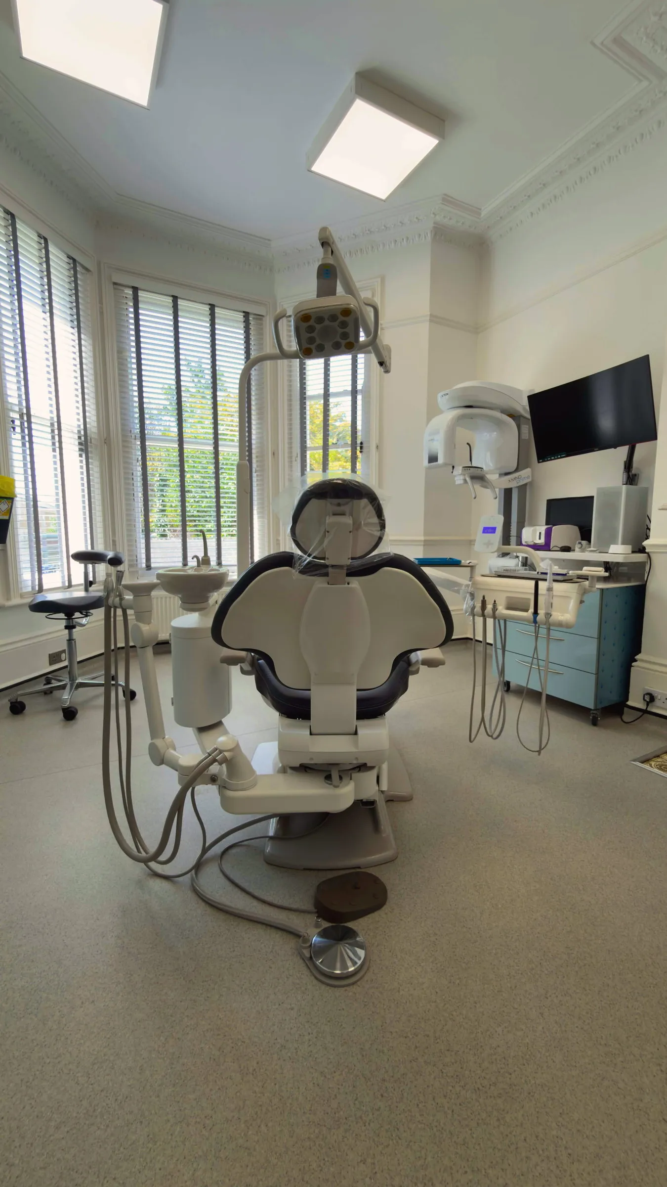 Modern treatment room with state-of-the-art dental chair and CBCT scanner