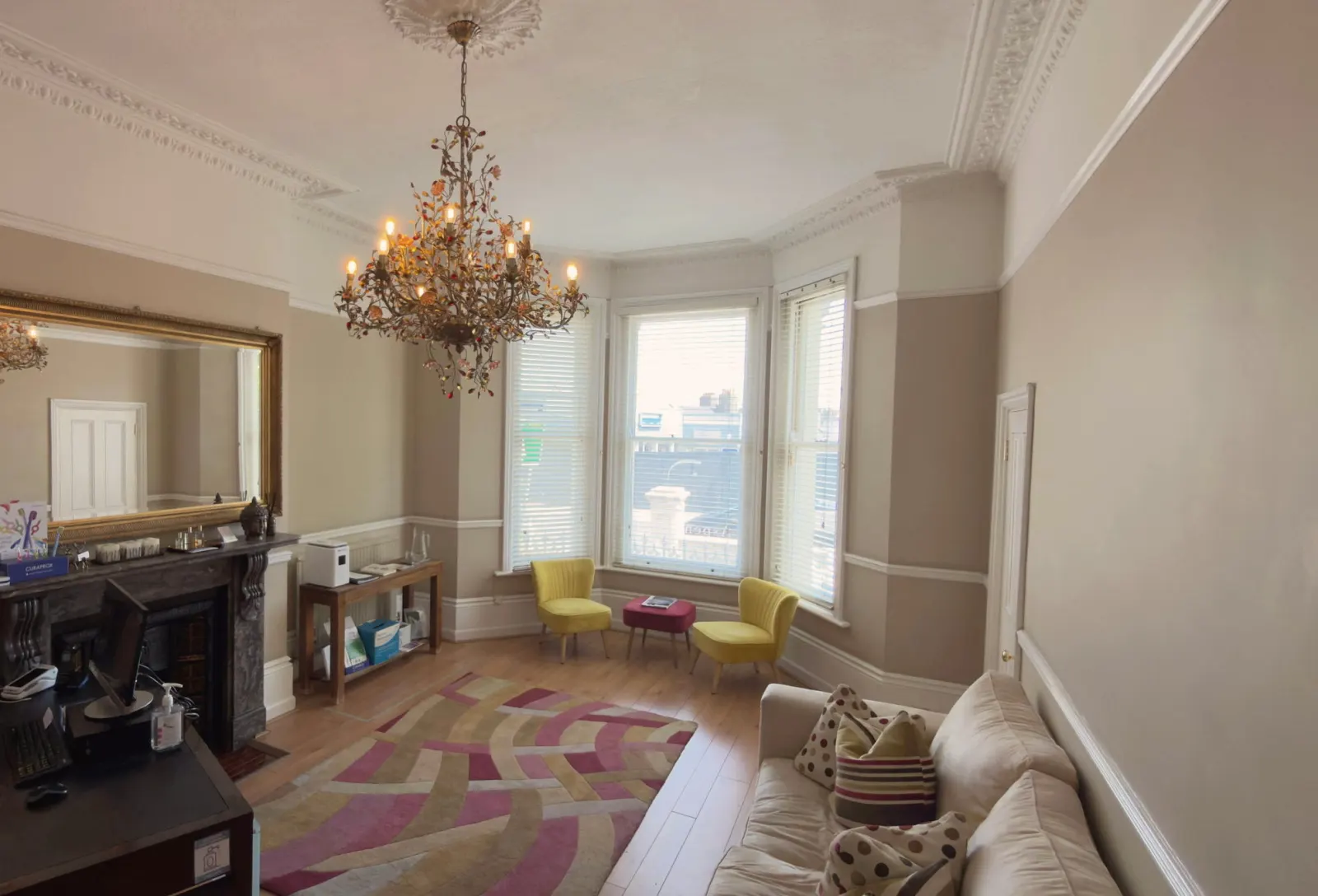 Elegant waiting room with chandelier, gilded mirror and bay windows
